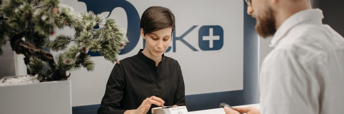 Customer makes a cashless payment at a clinic reception using wireless technology.